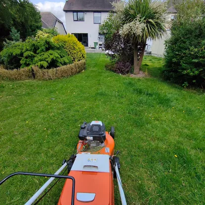 Lawn being mown as part of a regular garden maintenance visit